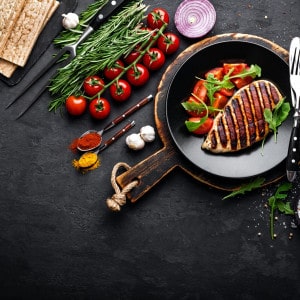 Grilled chicken fillet on black background. Top view