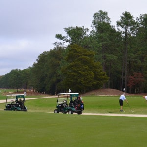 Golfers on a golf course putting golfing with golf carts, Pinehurst NC